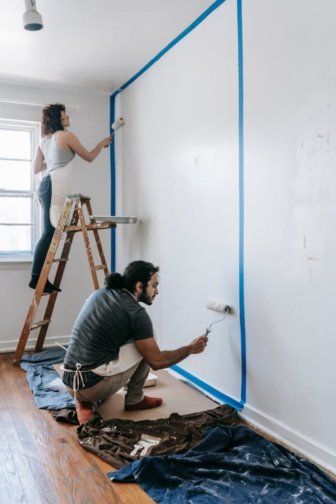 Couple working together on room painting project with rollers. Perfect for home improvement themes.