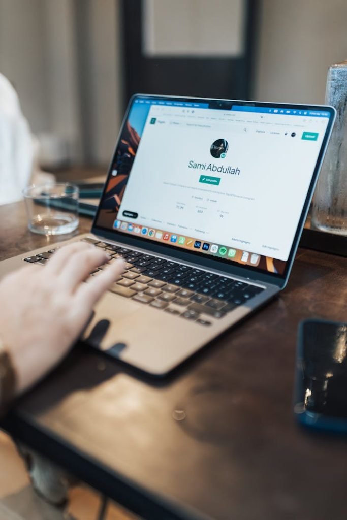 A focused shot of a person using a laptop indoors, highlighting device interaction.